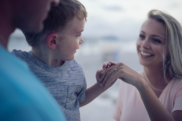 Un enfant regarde la bague de fiançailles de sa maman