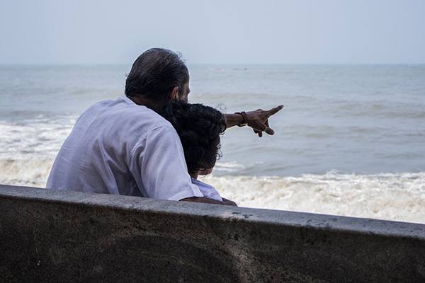 Grand-père avec son petit-enfant devant l'océan