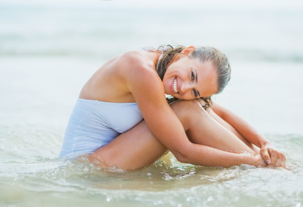 Jeune femme dans la mer en maillot de bain 1 pièce