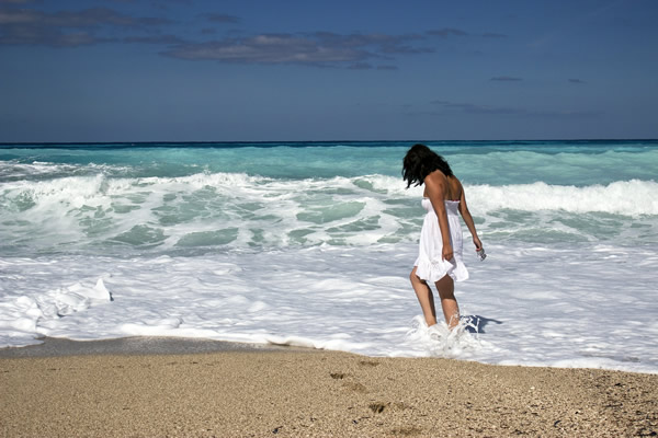 Une femme qui marche au bord de la mer