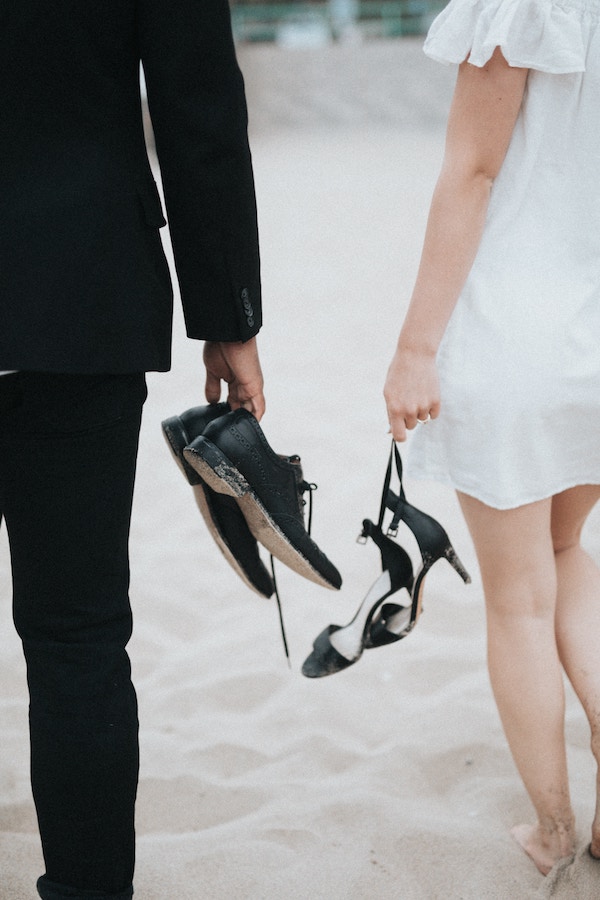 Couple de jeunes mariés pieds nus dans le sable