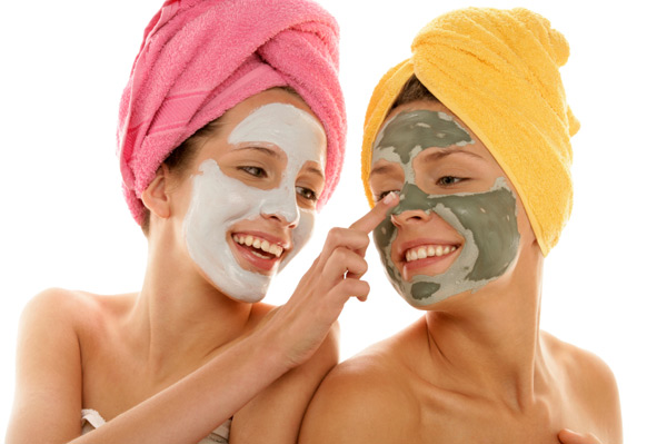 Deux femmes qui ont un masque facial en argile sur le visage.
