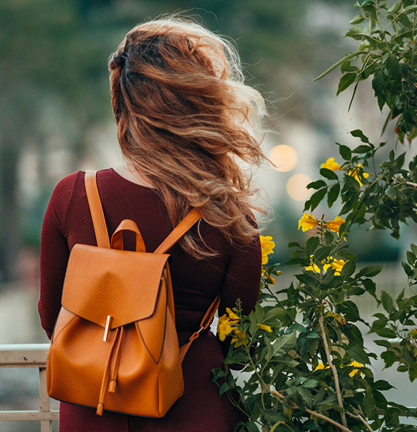 Une femme qui porte un sac à dos en cuir