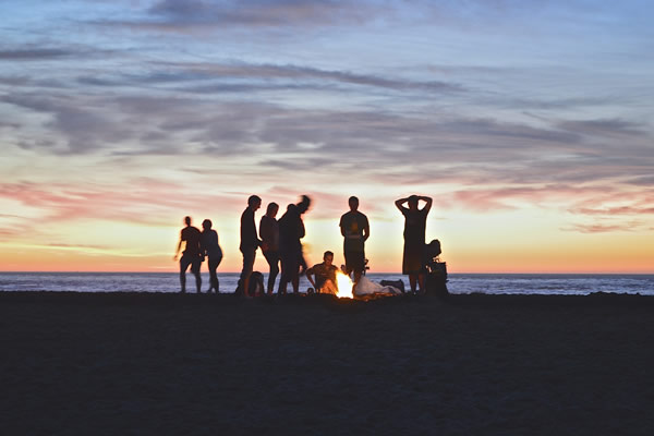 Vacances entre amis, un feu allumé sur la plage la nuit