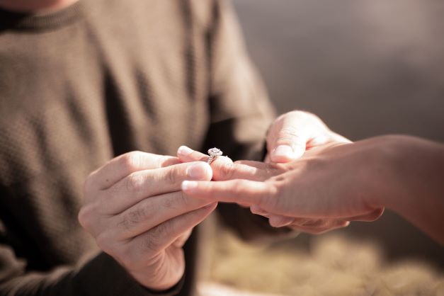 Une photo d'une demande en mariage avec un gros plan sur la bague